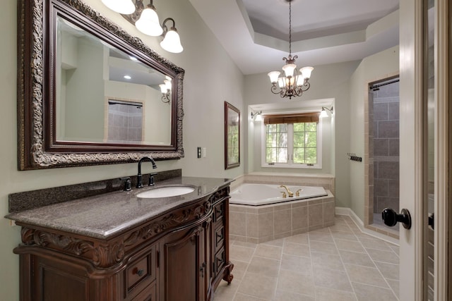 full bathroom featuring a tray ceiling, an inviting chandelier, a bath, tile patterned flooring, and vanity