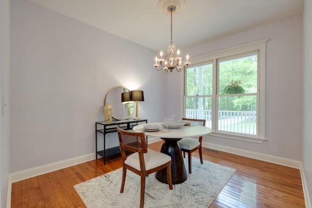 dining space with baseboards, a chandelier, visible vents, and plenty of natural light