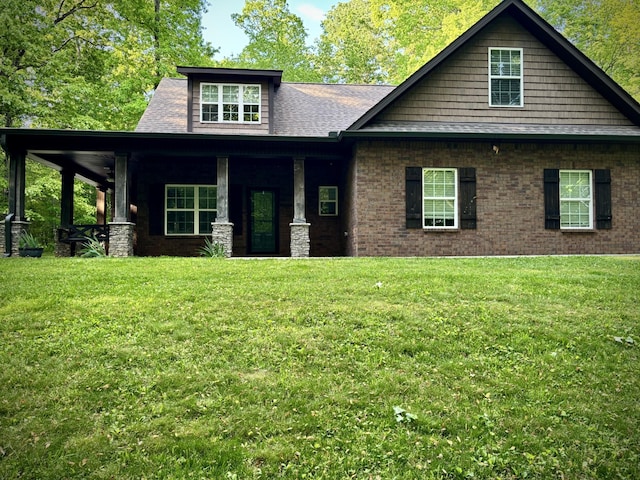 craftsman house featuring covered porch, brick siding, a shingled roof, and a front lawn
