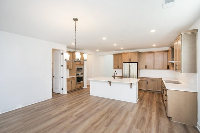 126 W Cassa Way, Mount Juliet, TN 37122 - kitchen with appliances with stainless steel finishes, a sink, a kitchen breakfast bar, light countertops, and light wood-type flooring