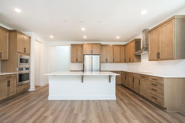 126 W Cassa Way, Mount Juliet, TN 37122 - kitchen featuring a breakfast bar, light wood-type flooring, wall chimney exhaust hood, a kitchen island, and appliances with stainless steel finishes