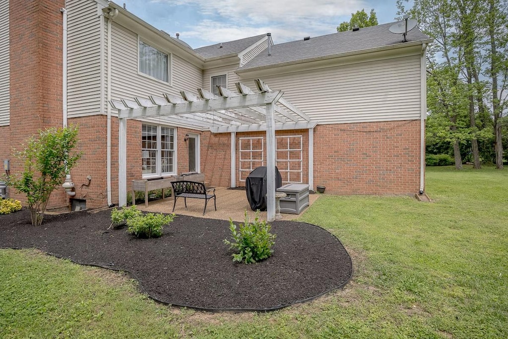 back of house with a yard, brick siding, a pergola, and a patio
