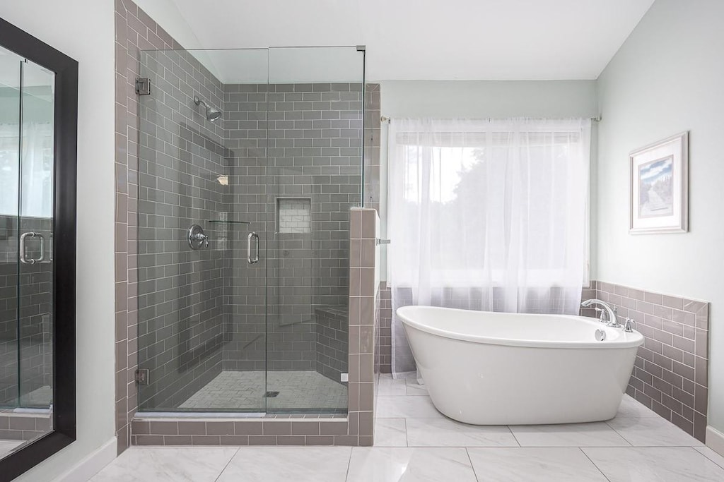 bathroom with a soaking tub and a stall shower