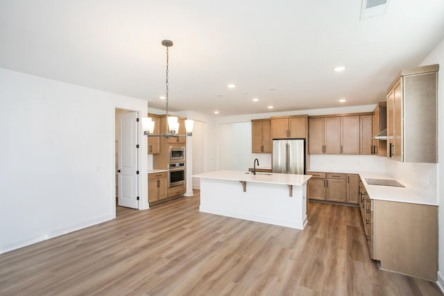 132 W Cassa Way, Mount Juliet, TN 37122 - kitchen with a sink, stainless steel appliances, a breakfast bar, light countertops, and light wood-style floors