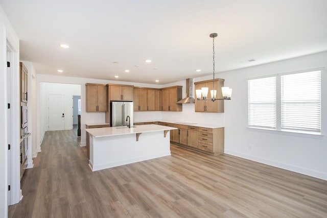 132 W Cassa Way, Mount Juliet, TN 37122 - kitchen with a sink, wall chimney range hood, brown cabinets, a chandelier, and appliances with stainless steel finishes