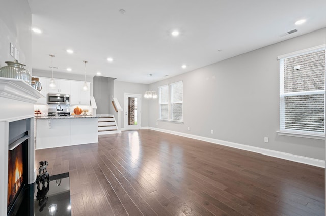 2131 Gunwale Mews, Franklin, TN 37064 - unfurnished living room with stairway, baseboards, recessed lighting, dark wood finished floors, and a warm lit fireplace