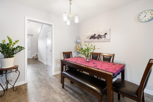 dining space with baseboards, stairs, and wood finished floors