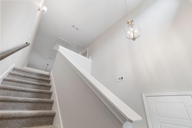 staircase featuring an inviting chandelier and visible vents