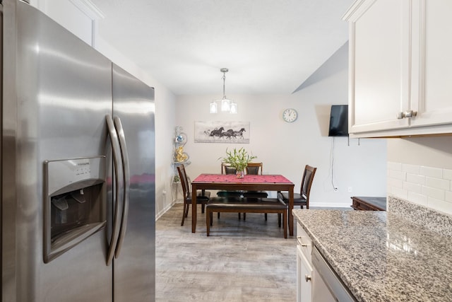 kitchen with light stone countertops, baseboards, stainless steel fridge with ice dispenser, light wood-style floors, and white cabinets