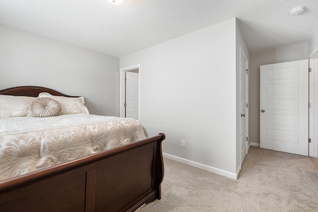 bedroom with light colored carpet and baseboards