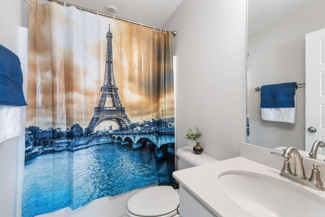 bathroom with toilet, vanity, and a textured ceiling