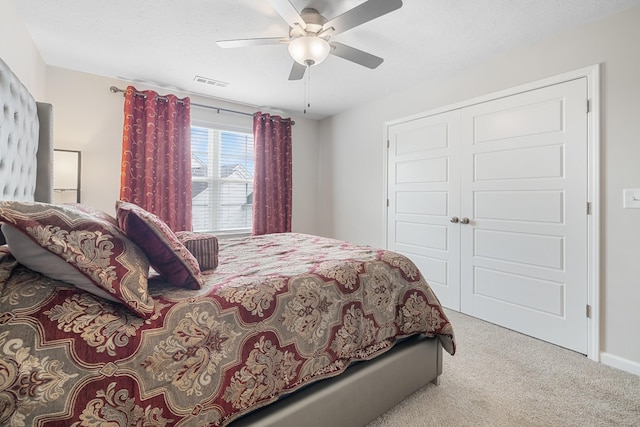 bedroom featuring a closet, visible vents, carpet floors, a ceiling fan, and baseboards