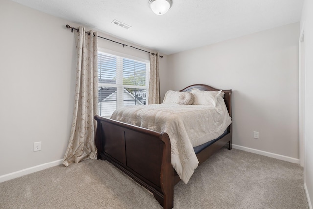 bedroom with baseboards, visible vents, and carpet