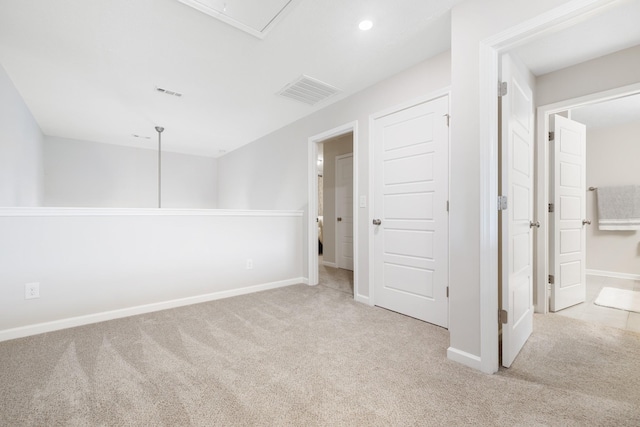 unfurnished bedroom featuring attic access, baseboards, carpet flooring, and visible vents