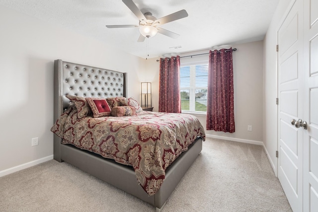 bedroom with light colored carpet, baseboards, and a ceiling fan