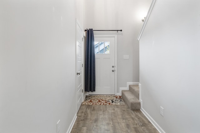 doorway to outside featuring stairs, baseboards, and wood finished floors