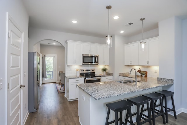 2804 Sonoma Way, Columbia, TN 38401 - kitchen featuring a sink, a peninsula, arched walkways, white cabinets, and appliances with stainless steel finishes