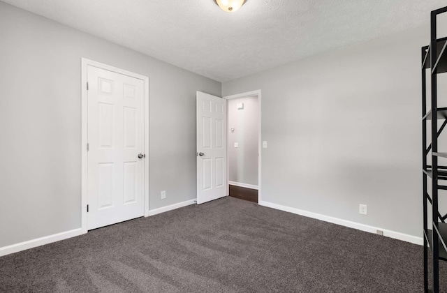 5000 Trailwater Dr, Antioch, TN 37013 - unfurnished bedroom with dark carpet, baseboards, and a textured ceiling
