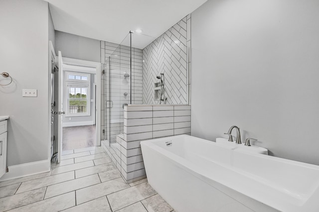 2221 10th Ave S, Nashville, TN 37204 - full bathroom with a stall shower, a freestanding tub, vanity, baseboards, and tile patterned flooring