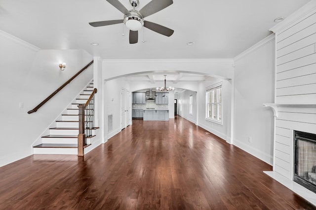 2221 10th Ave S, Nashville, TN 37204 - unfurnished living room featuring arched walkways, a glass covered fireplace, ceiling fan, dark wood finished floors, and stairs