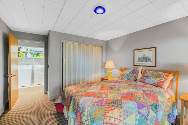 carpeted bedroom with baseboards, a closet, and washing machine and dryer