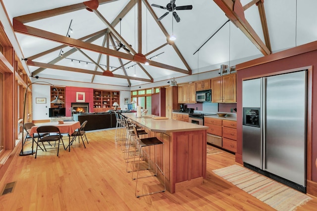 kitchen with stainless steel appliances, visible vents, high vaulted ceiling, light countertops, and light wood-type flooring