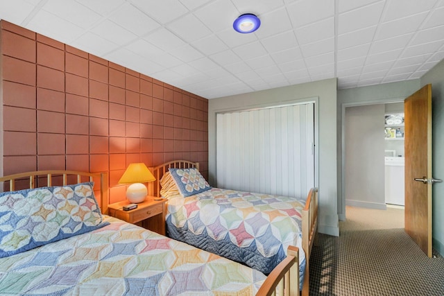 bedroom featuring carpet floors, a closet, and washer / dryer