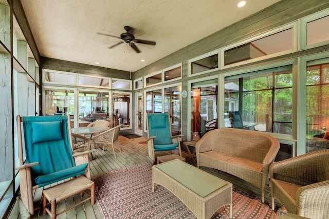 sunroom / solarium featuring outdoor dining area, a ceiling fan, and plenty of natural light