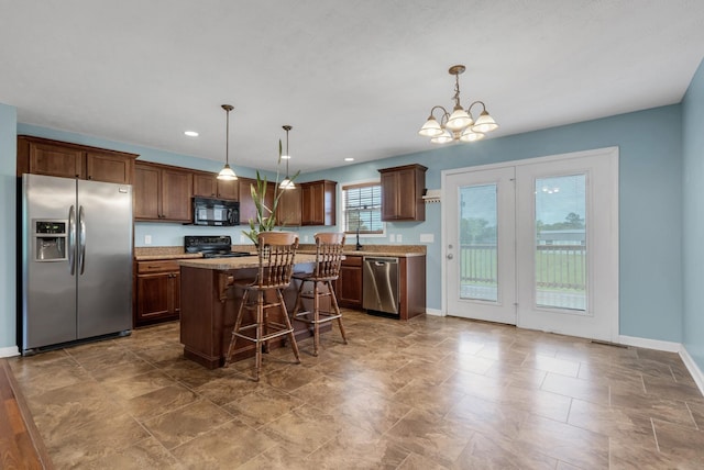 kitchen with baseboards, a breakfast bar, an inviting chandelier, a kitchen island, and black appliances
