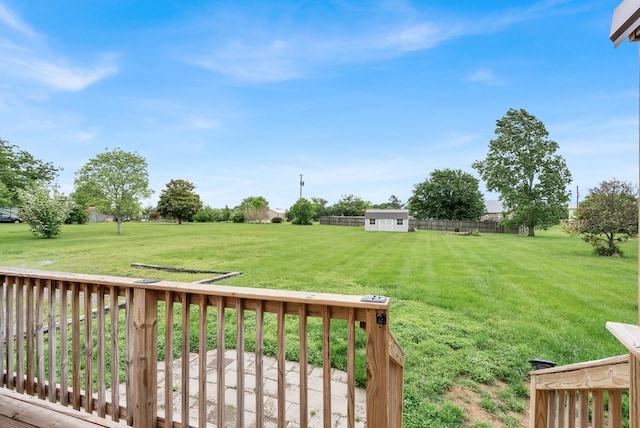 view of yard featuring a deck, an outdoor structure, and a storage unit