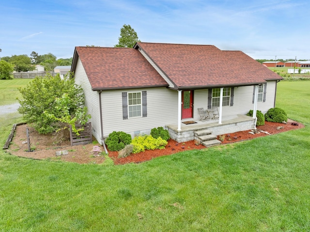 view of front of house with a porch, a shingled roof, and a front yard