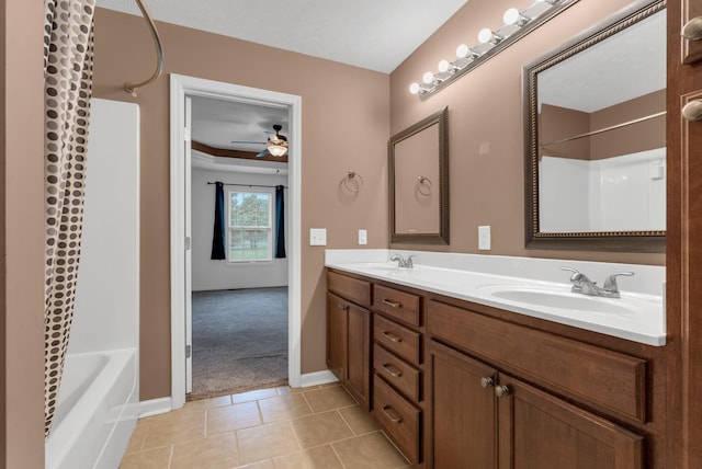 bathroom with double vanity, a ceiling fan, a sink, tile patterned floors, and baseboards