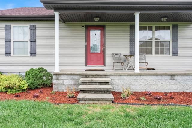 property entrance with covered porch and a shingled roof