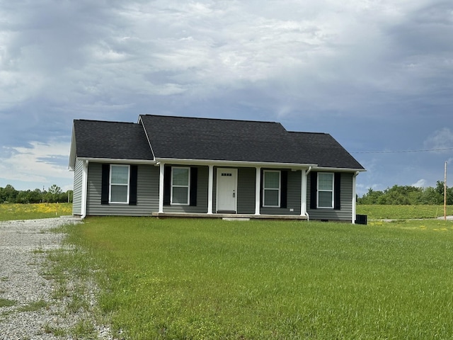 view of front of house featuring covered porch, driveway, a shingled roof, and a front yard