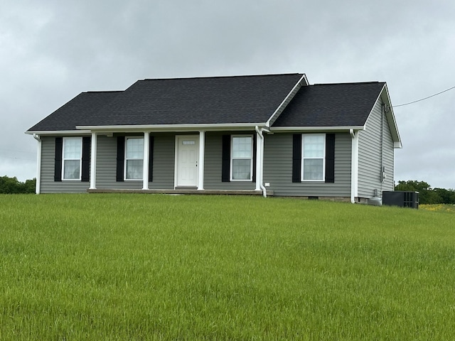 ranch-style house featuring a front yard, a porch, roof with shingles, and cooling unit