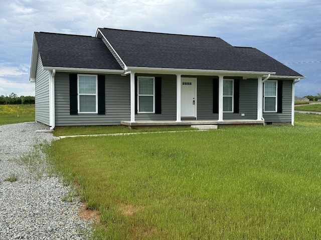 view of front of property with covered porch, a shingled roof, and a front yard