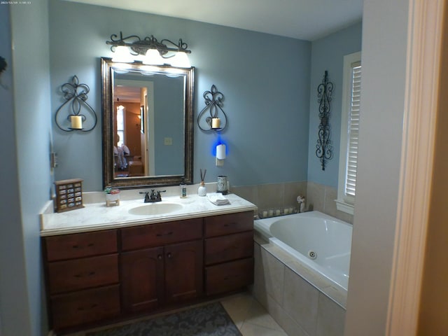 bathroom featuring a tub with jets, vanity, and tile patterned flooring