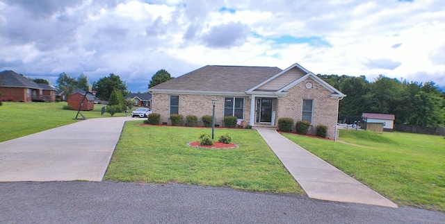 view of front of house featuring driveway, brick siding, and a front lawn