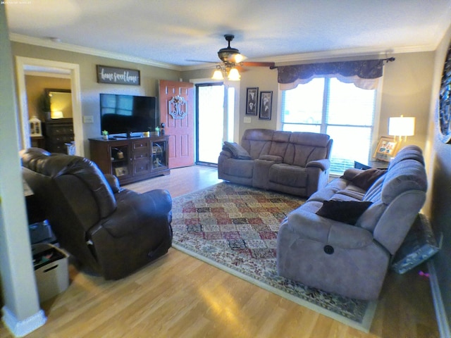 living room with ornamental molding, a ceiling fan, and wood finished floors
