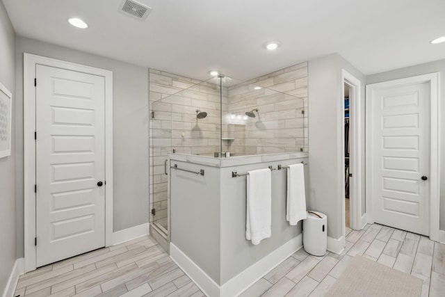 full bath with baseboards, tiled shower, visible vents, and recessed lighting