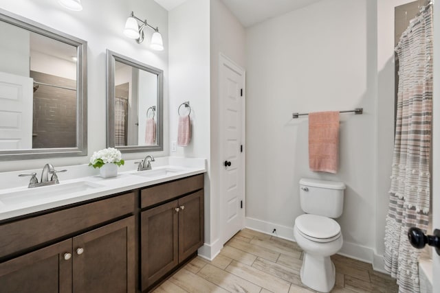 full bathroom with a sink, toilet, wood tiled floor, and baseboards