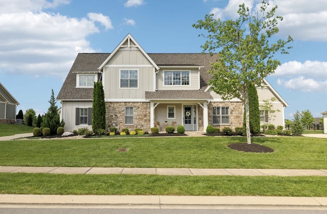 craftsman inspired home with board and batten siding, stone siding, and a front yard