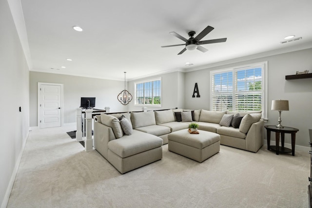 living area with light colored carpet, a wealth of natural light, baseboards, and visible vents