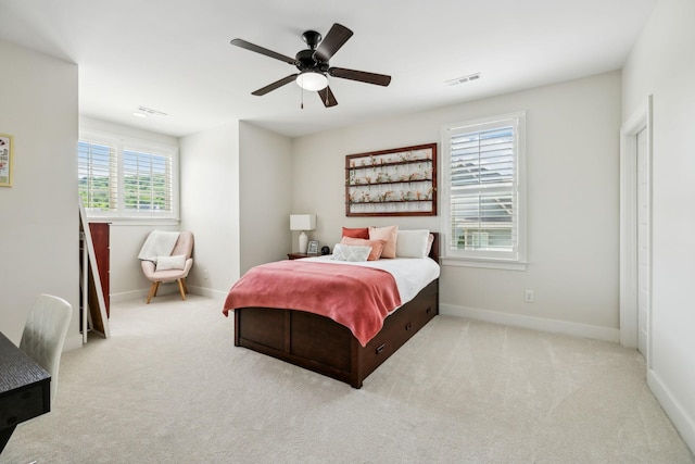 carpeted bedroom with visible vents, baseboards, and a ceiling fan