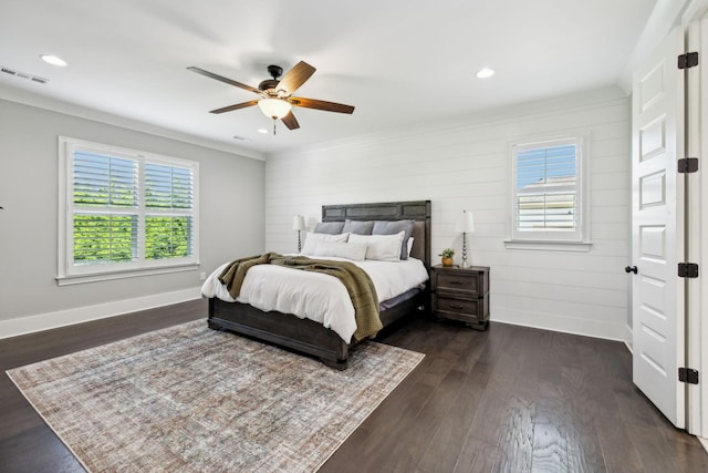 bedroom with multiple windows, visible vents, dark wood-style flooring, and crown molding