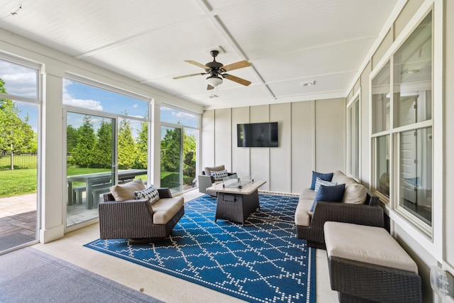 sunroom / solarium with a decorative wall, ceiling fan, carpet, and outdoor lounge area