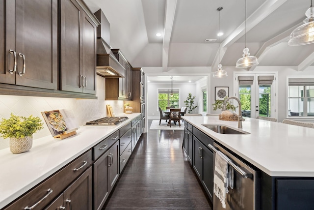 kitchen with a sink, light countertops, dark wood-style floors, and appliances with stainless steel finishes