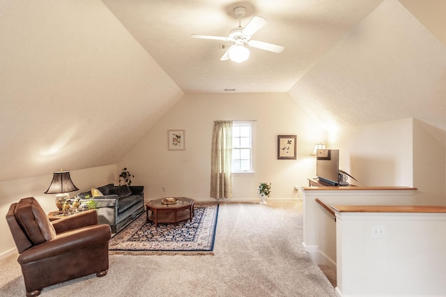 interior space with ceiling fan, lofted ceiling, carpet, and baseboards