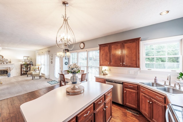 kitchen featuring range, stainless steel dishwasher, a sink, a chandelier, and light countertops