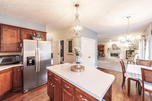 kitchen featuring a chandelier, light countertops, open floor plan, dark wood-style floors, and stainless steel fridge with ice dispenser